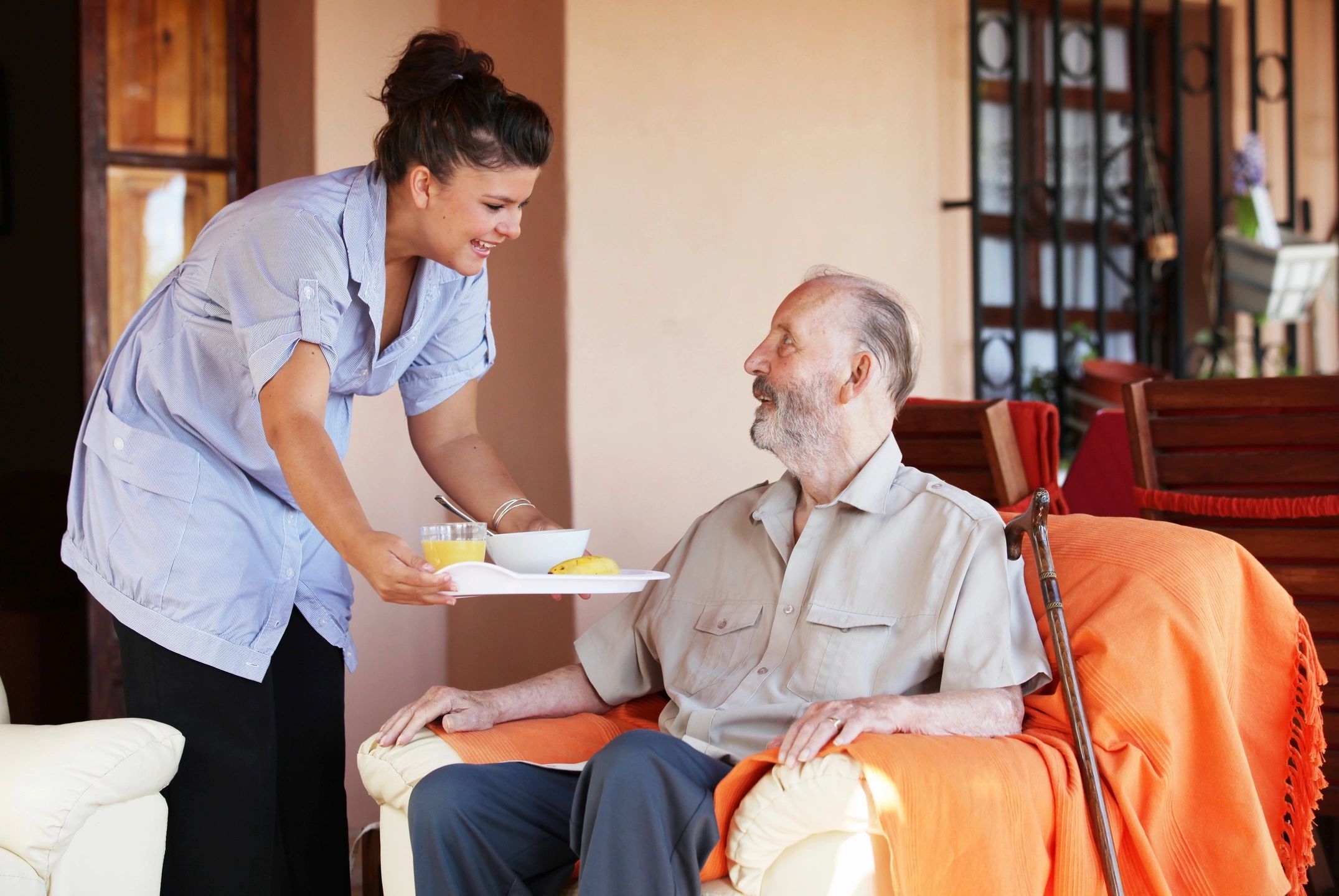 Caregiver serving a meal to an elderly resident